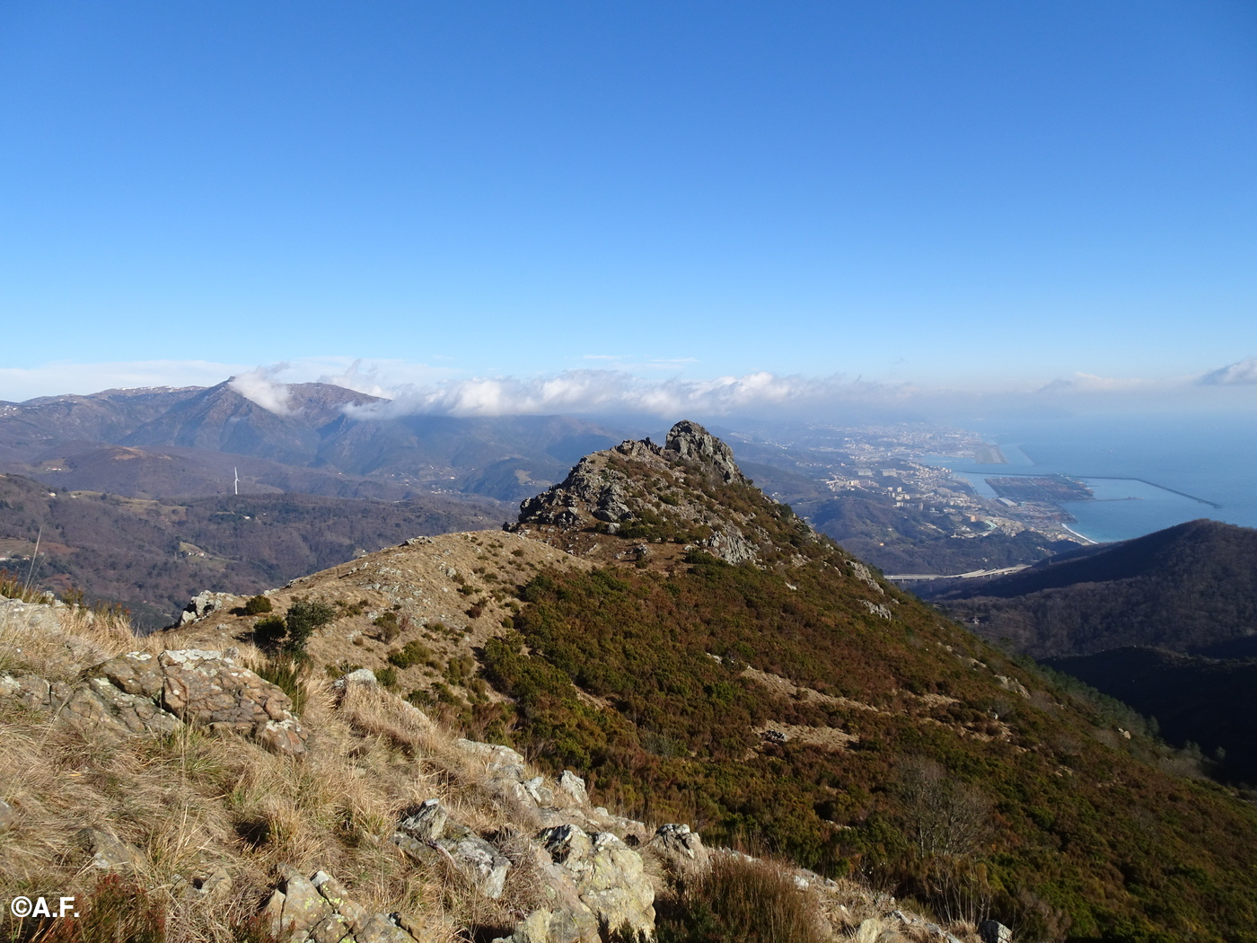 Il Bric Rocca dei Gatti visto da ovest; sullo sfondo Punta Martín, il porto di Prà e il mare