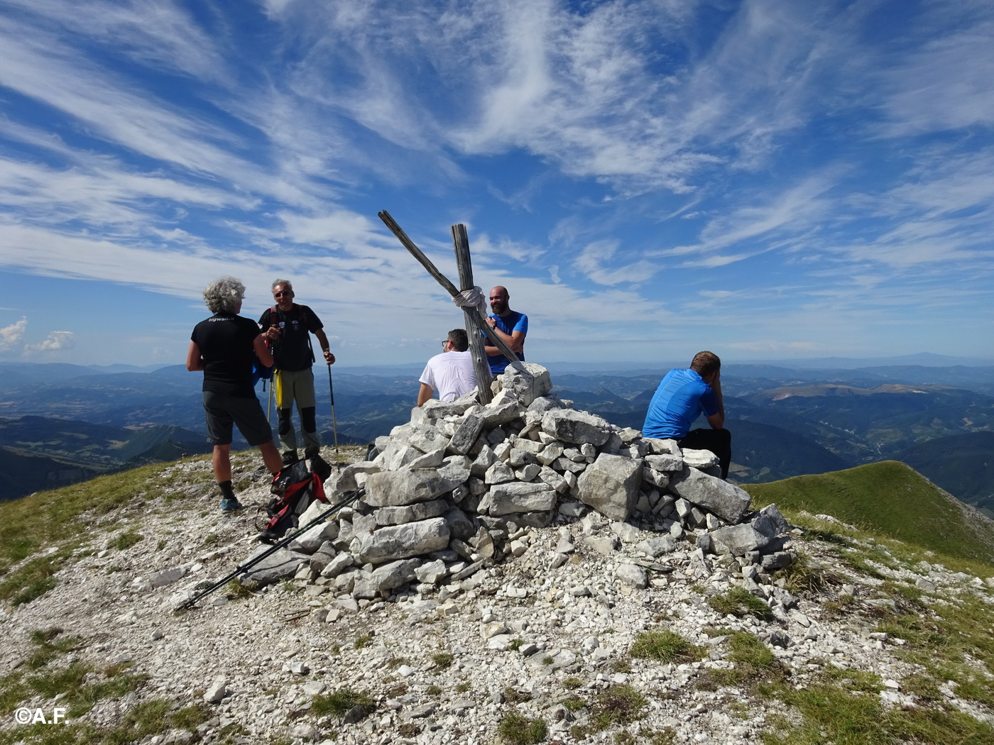 La croce di vetta; sullo sfondo a destra, lontanissimo, il Monte Amiata